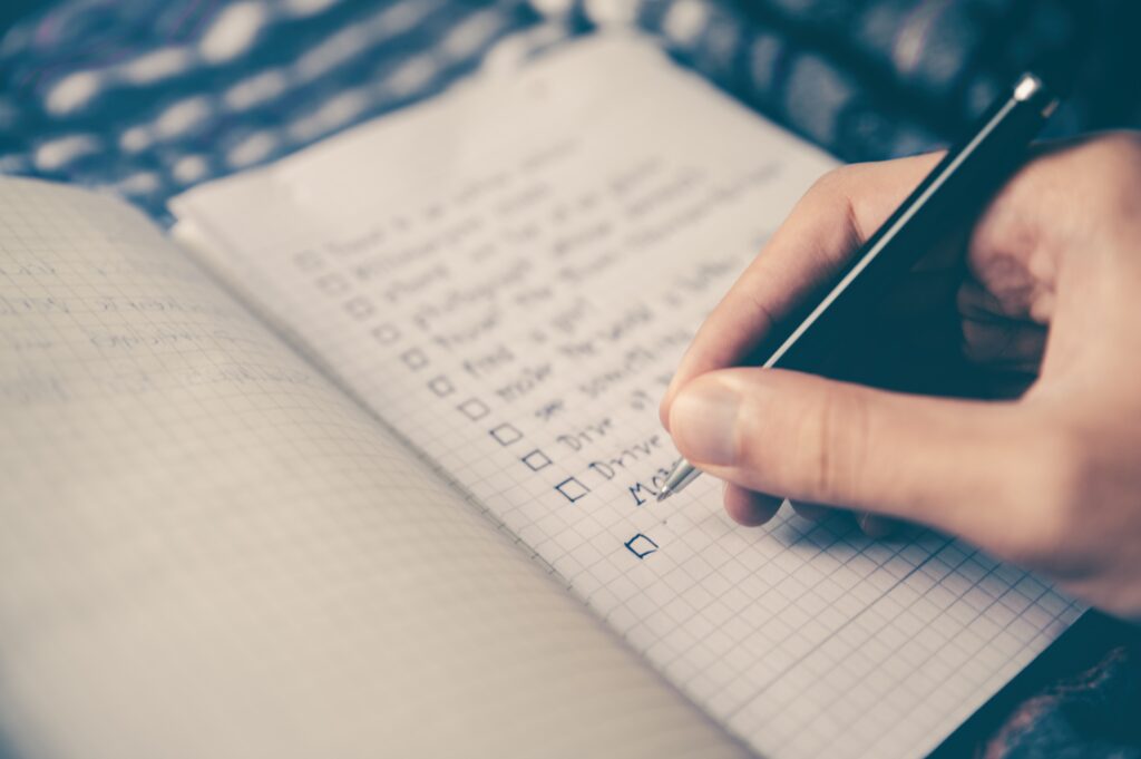 Close-up of someone writing a bullet-pointed list