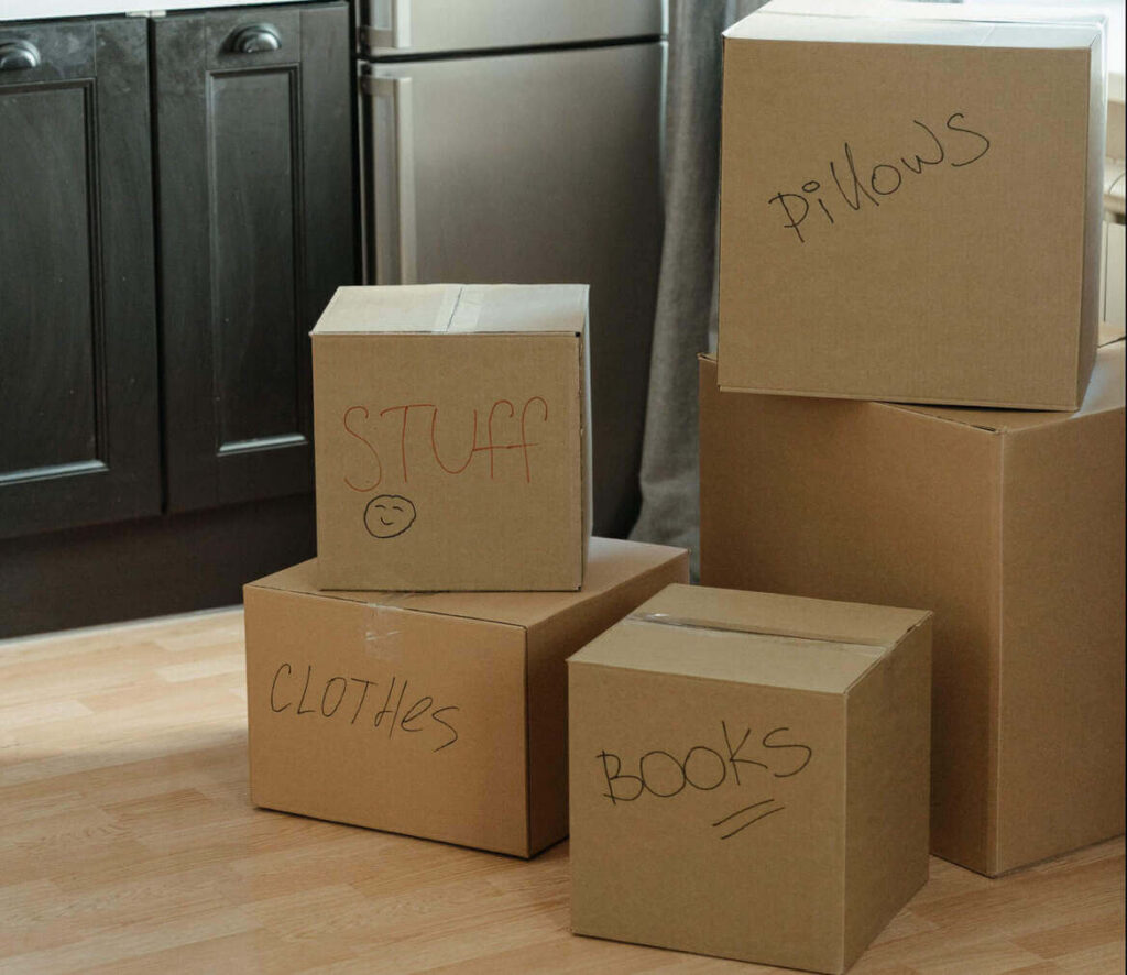 Cardboard storage boxes with items written on the boxes with pen